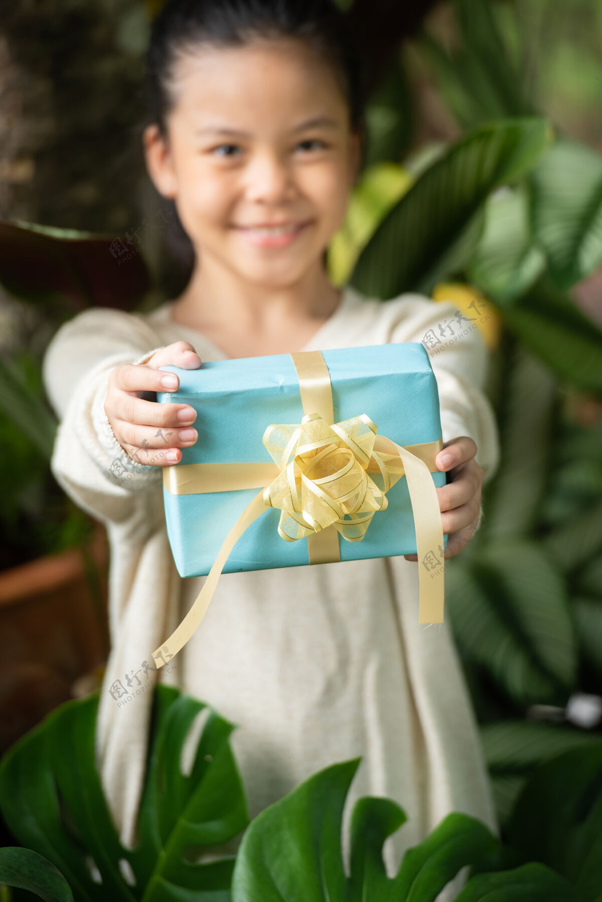 工艺圣诞画像快乐微笑的小女孩和礼品盒附近的绿色树枝树木头树叶盒子