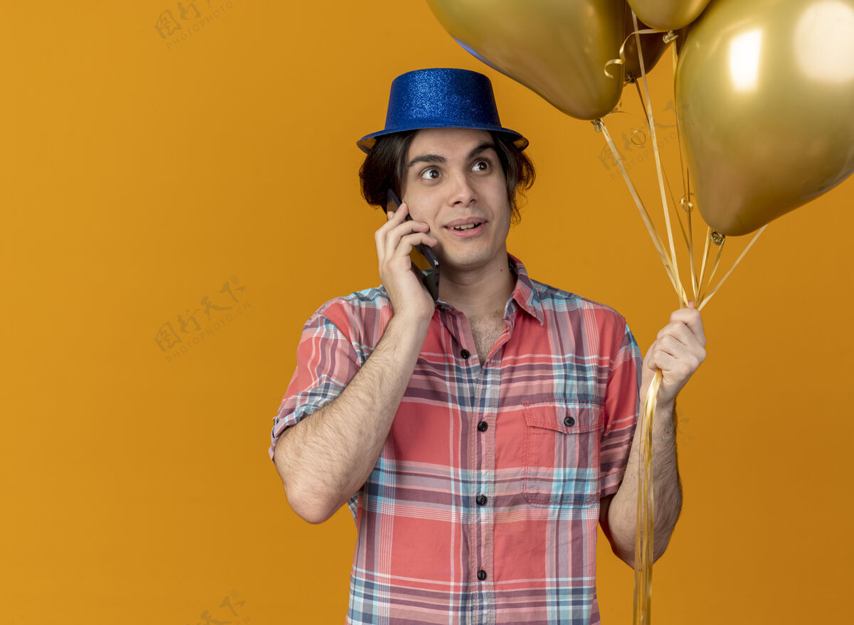 电话帅气的白种人戴着蓝色派对帽手持氦气球打电话男人帽子气球