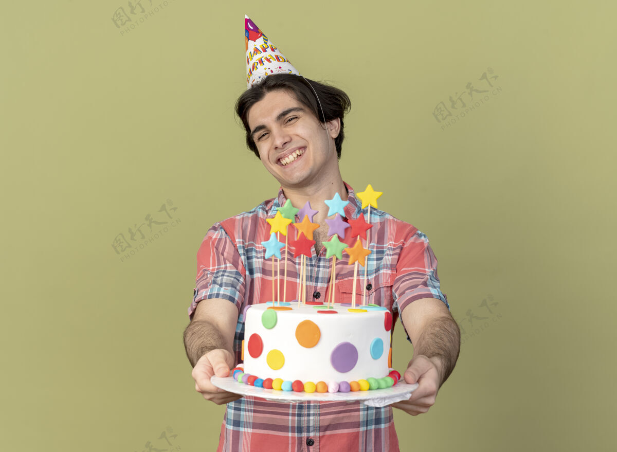 蛋糕笑容可掬的高加索帅哥戴着生日帽拿着生日蛋糕空间举行男人