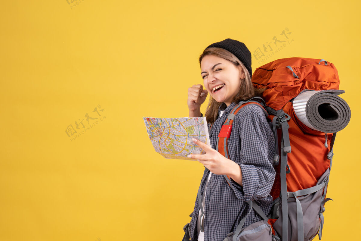 表情背着背包拿着地图的年轻旅行者欣喜若狂肖像成人背包