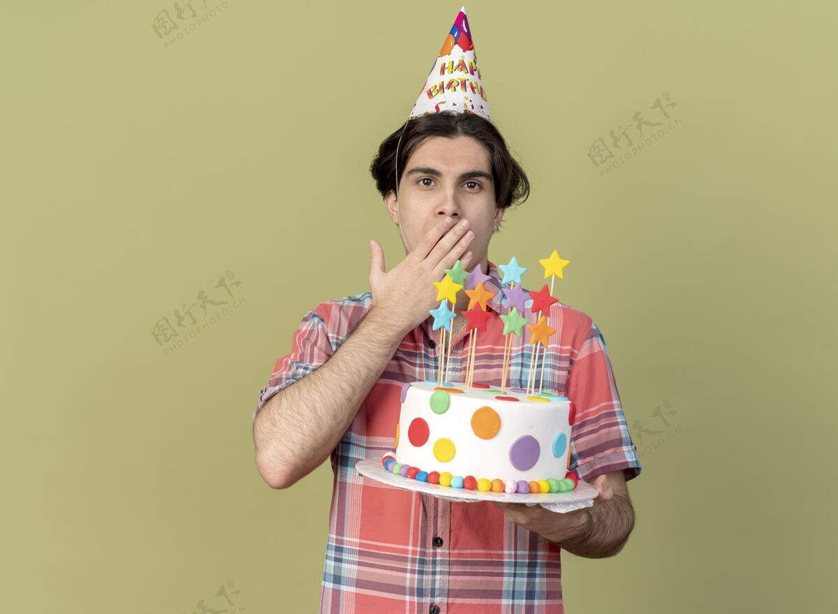 生日帅气的白种人戴着生日帽 手放在嘴上 手里拿着生日蛋糕嘴帽子印象