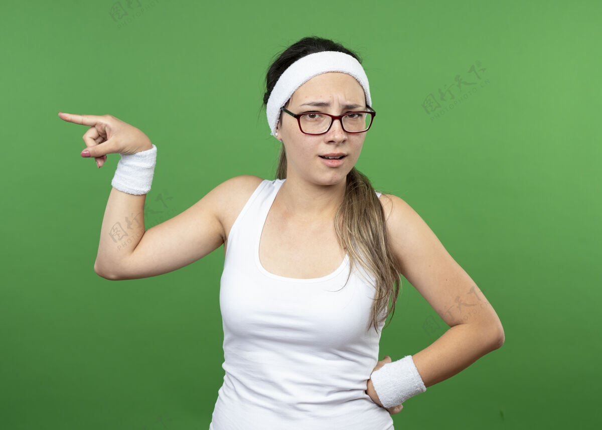 空间戴着眼镜 戴着头带和腕带的年轻运动型女孩站在一边光学眼镜绿色