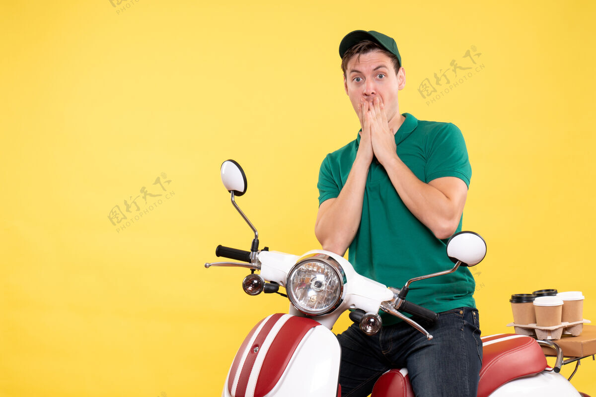 工作正面图：身穿黄色绿色制服的年轻男性信使车辆摩托车服务