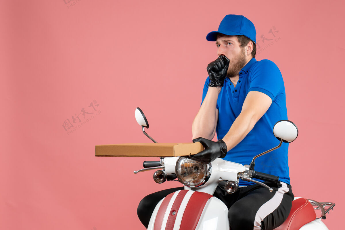 男信使正面图男性信使坐在自行车上 拿着一个粉红色的比萨饼盒自行车坐着工作