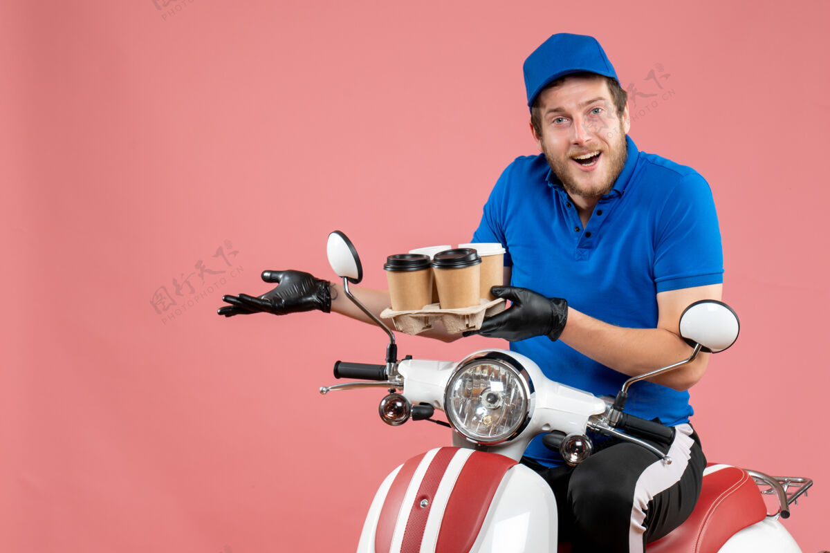 工作正面图男性信使坐在自行车上拿着咖啡杯在粉红色咖啡摩托车送货