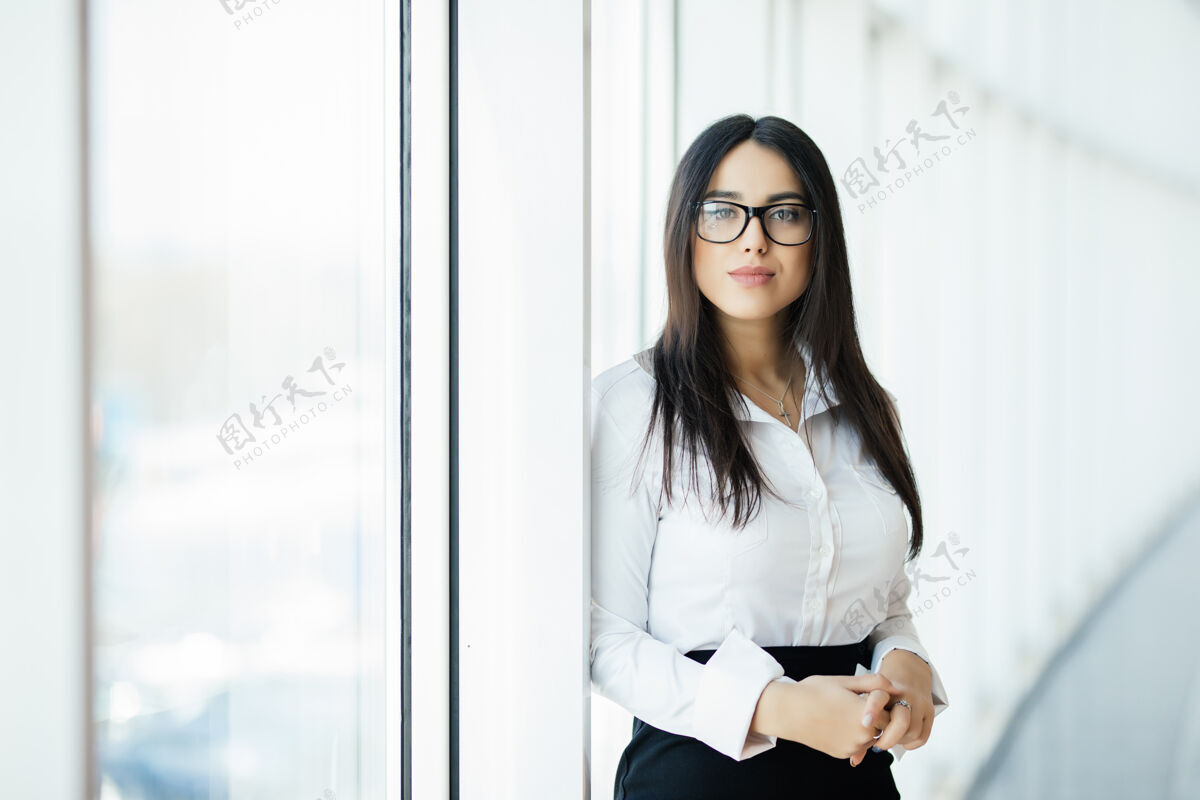 手臂戴眼镜的女商人双手交叉 办公室里有全景窗商业理念咨询女士日本人