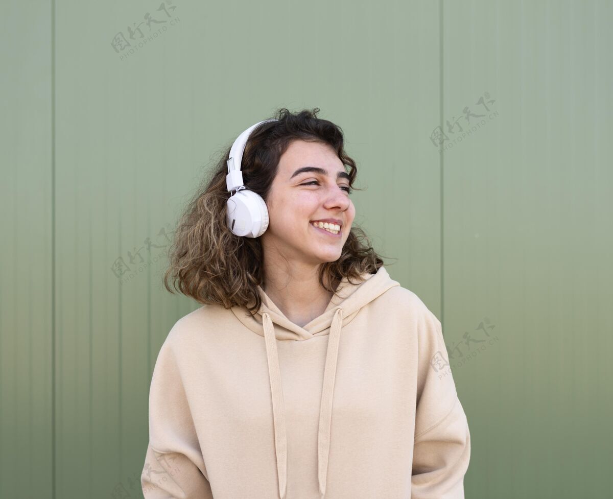 乐趣戴着耳机的中镜头快乐女孩享受活动青少年