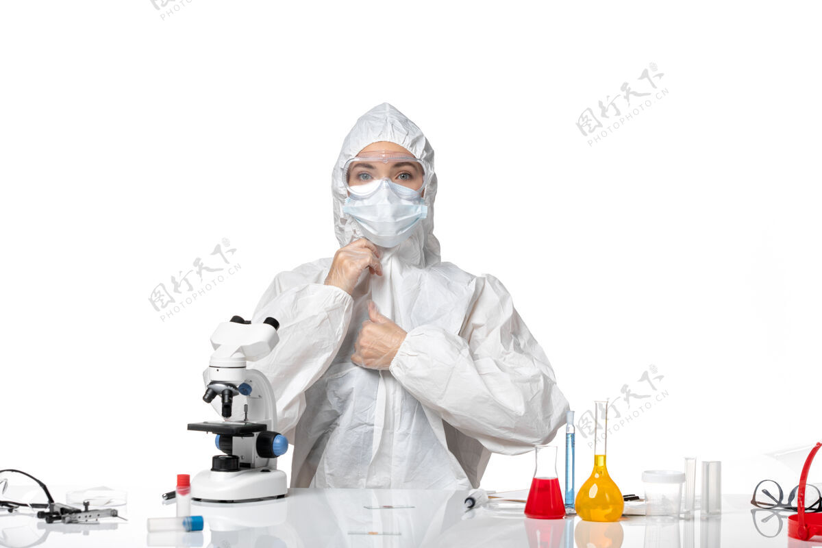 病毒正面图年轻女医生穿着白色防护服 戴着口罩 由于科维德在白色背景下工作 大流行性飞溅病毒健康科维德-套装实验室外套医生