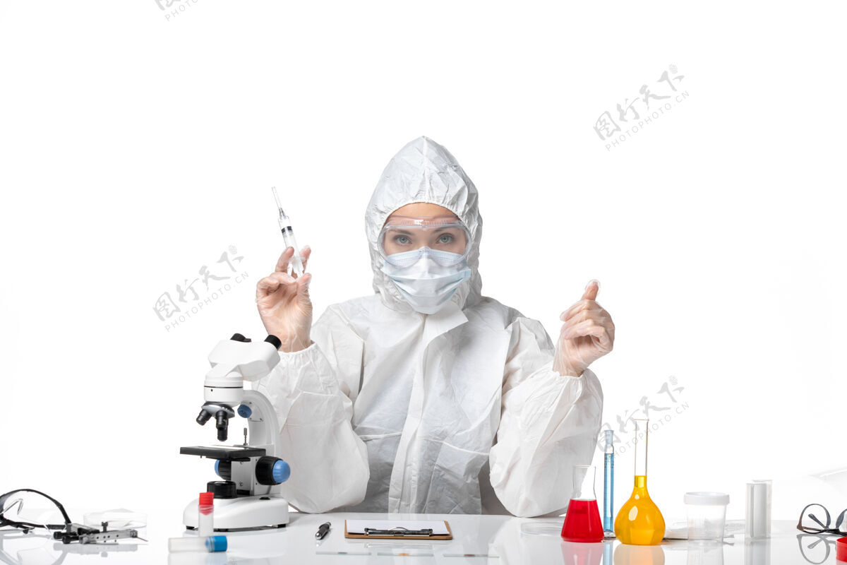 药正面图年轻女医生穿着防护服 戴着口罩 因为白色背景上的柯维德大流行柯维德病毒健康医生职业病毒