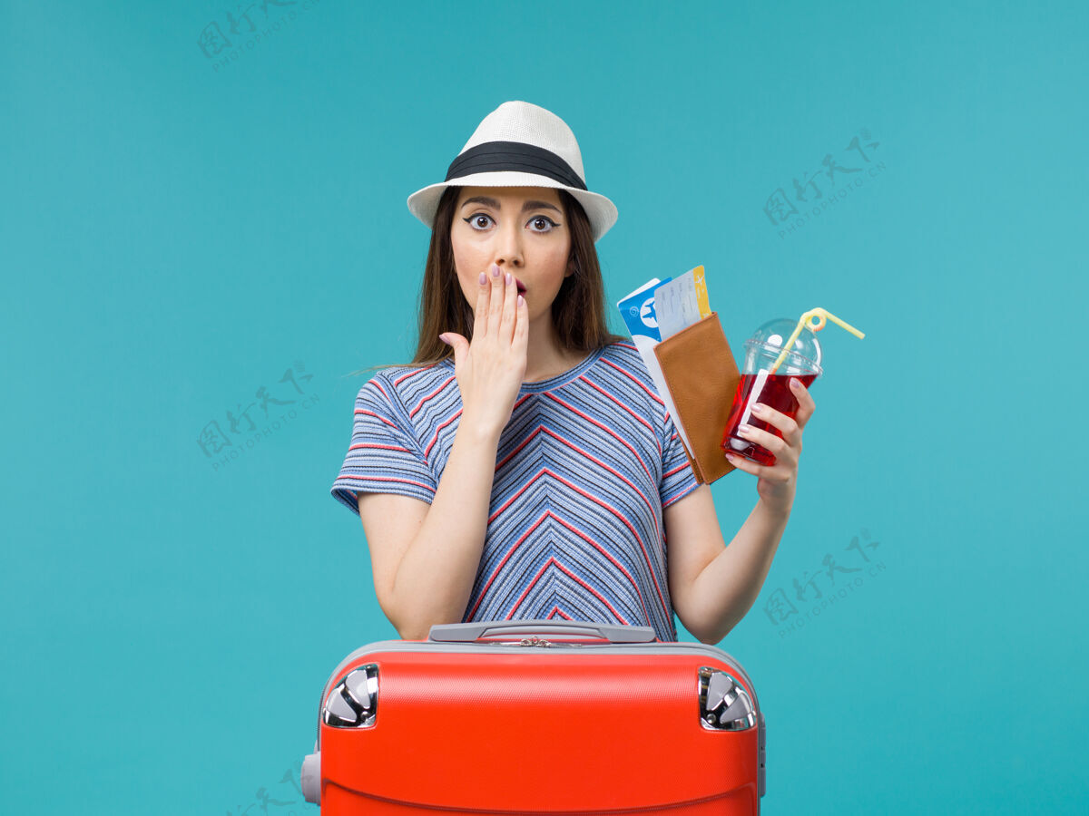 票前景度假中的女人拿着钱包拿着蓝色背景上的机票航海旅行女海飞机夏天航行微笑肖像
