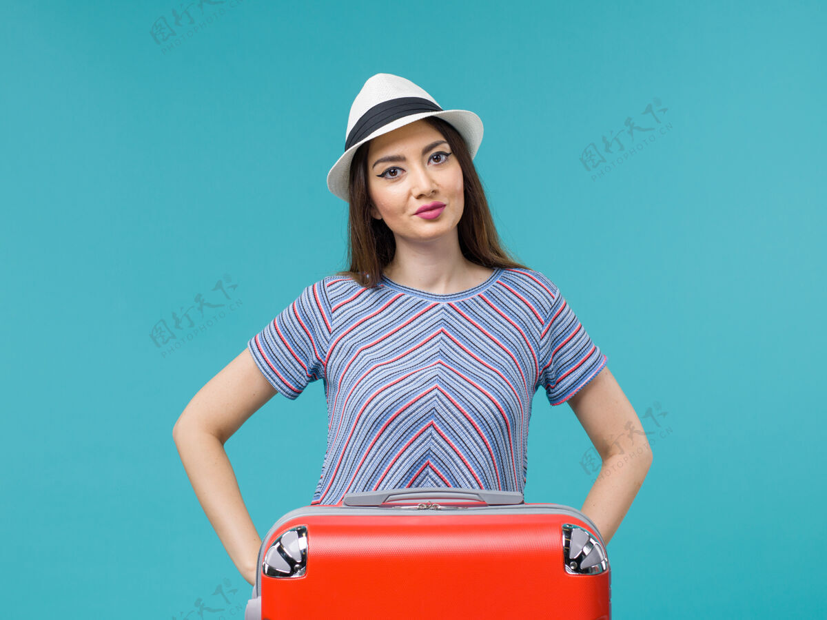 包前景色度假妇女与她的红色袋子享受她的蓝色背景旅行旅行旅行度假女性旅行人休闲旅行