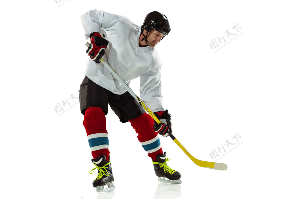 冬季年轻的男子冰球运动员 冰球场上的棍子和白墙运动员戴着设备和头盔练习动作人溜冰