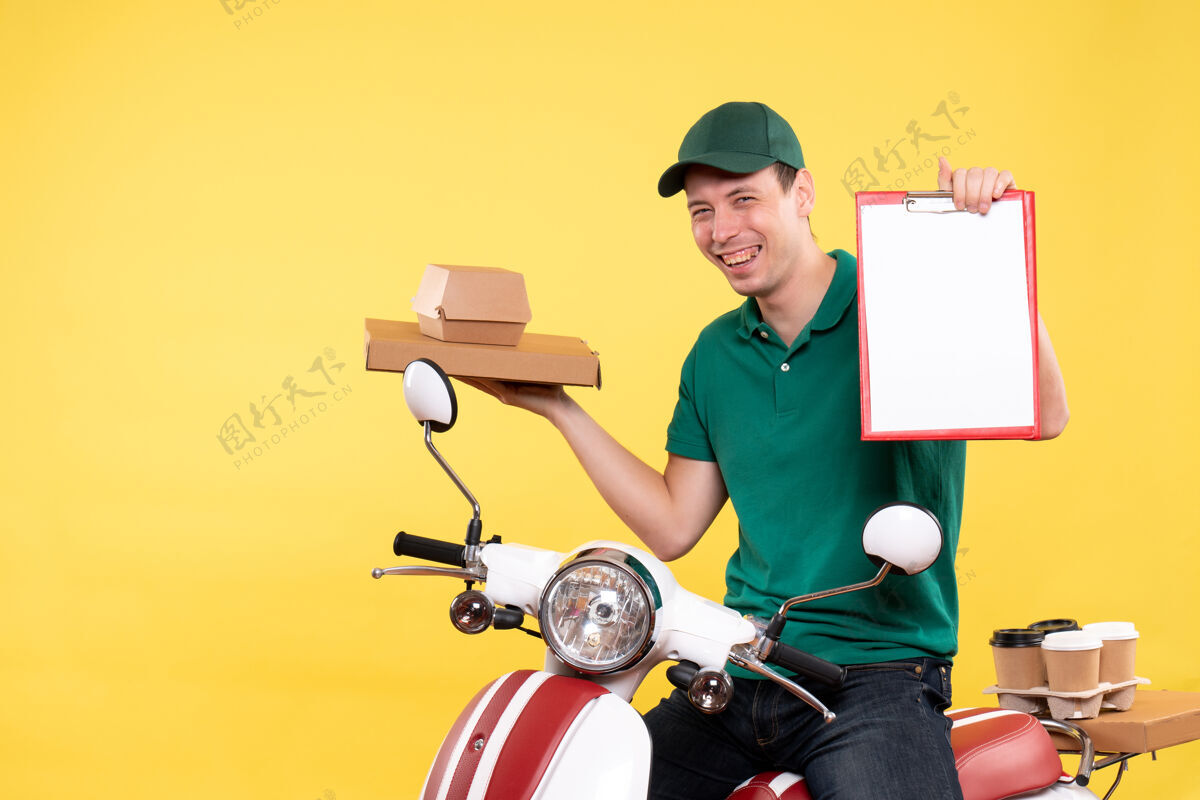 车辆正面图年轻的男信使穿着制服 手里拿着食品盒和黄色文件纸条工人输送机货舱