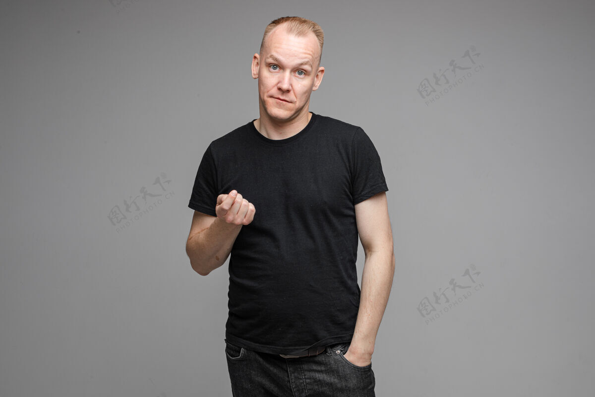 年轻人穿黑衬衫的成年男子用手做信标手势的照片白种人男性过来