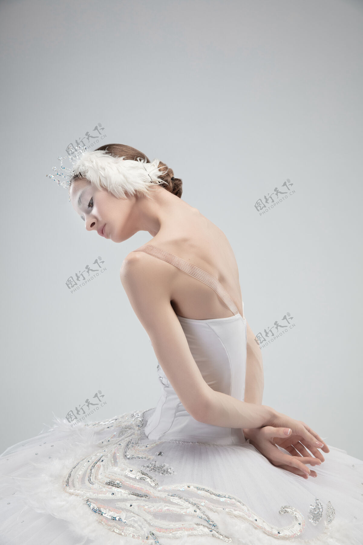 表演白色工作室背景上年轻优雅的芭蕾舞演员的特写镜头动作优雅平衡