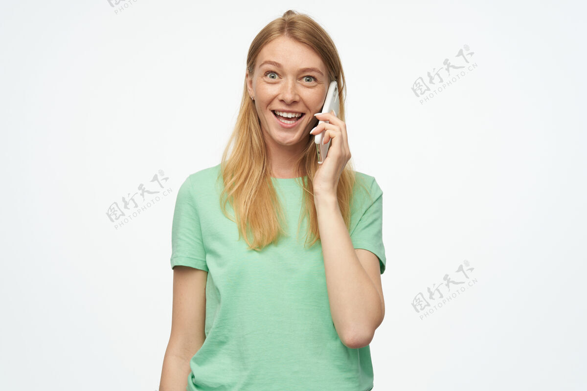 乐观满脸笑容的薄荷色雀斑美女看起来很开心 用白色手机聊天女性肖像欢呼
