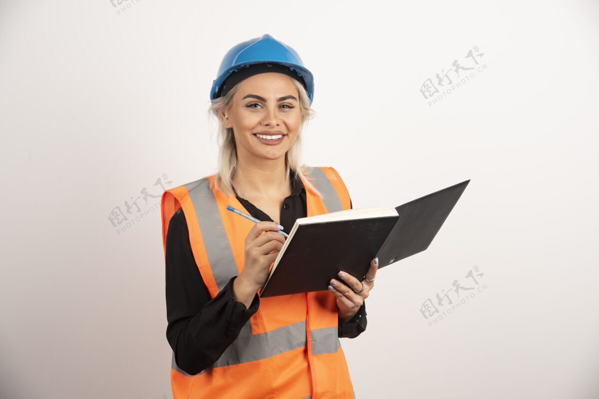 背心积极的建筑工人写在笔记本上高品质的照片头盔安全帽女孩