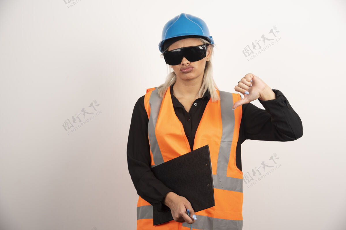 人戴眼镜的女工程师在白色背景上竖起大拇指高质量照片女背心剪贴板