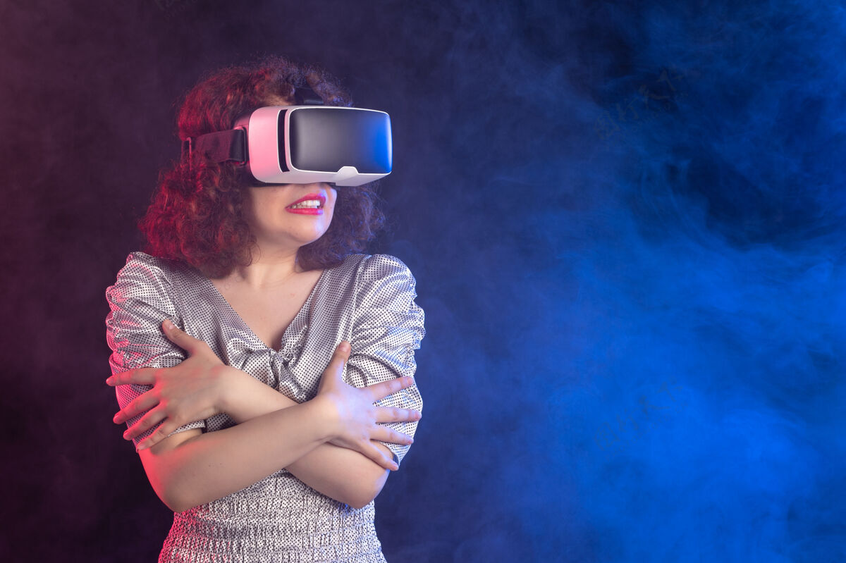 耳机年轻女性戴着虚拟现实耳机在深蓝色的表面虚拟年轻女性游戏