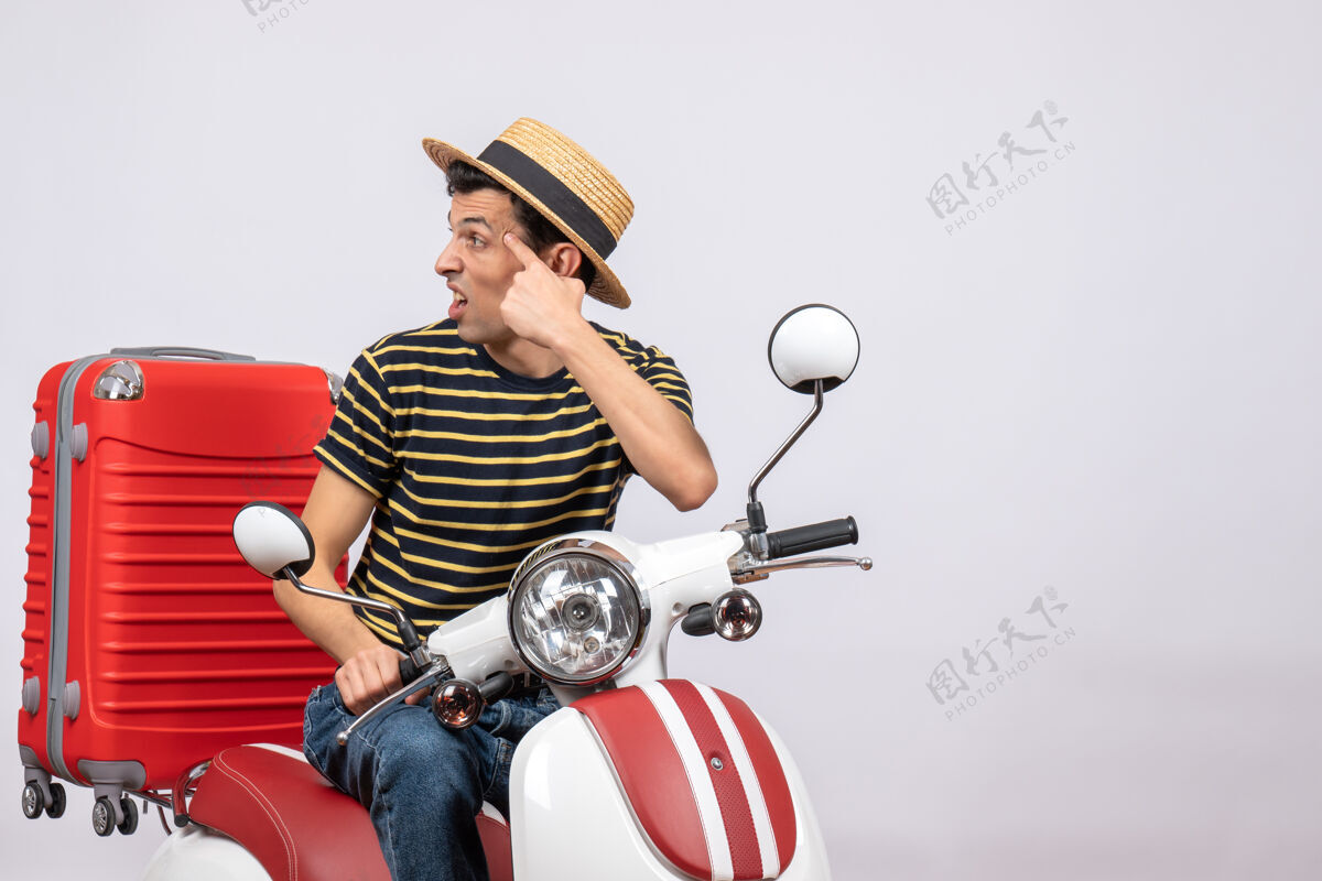 前面一个戴着草帽的年轻人坐在轻便摩托车上看左边帽子车辆年轻人