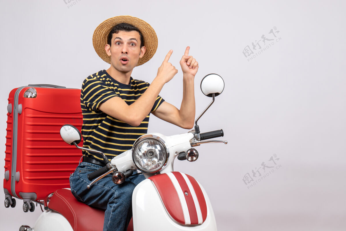 指向一个戴着草帽的年轻人正对着后面传送带摩托车轻便摩托车