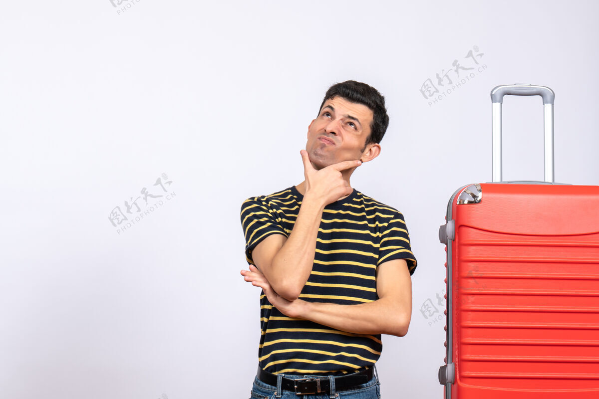 年轻男士正面图：穿着条纹t恤和红色手提箱的年轻人在想什么休闲男士正面