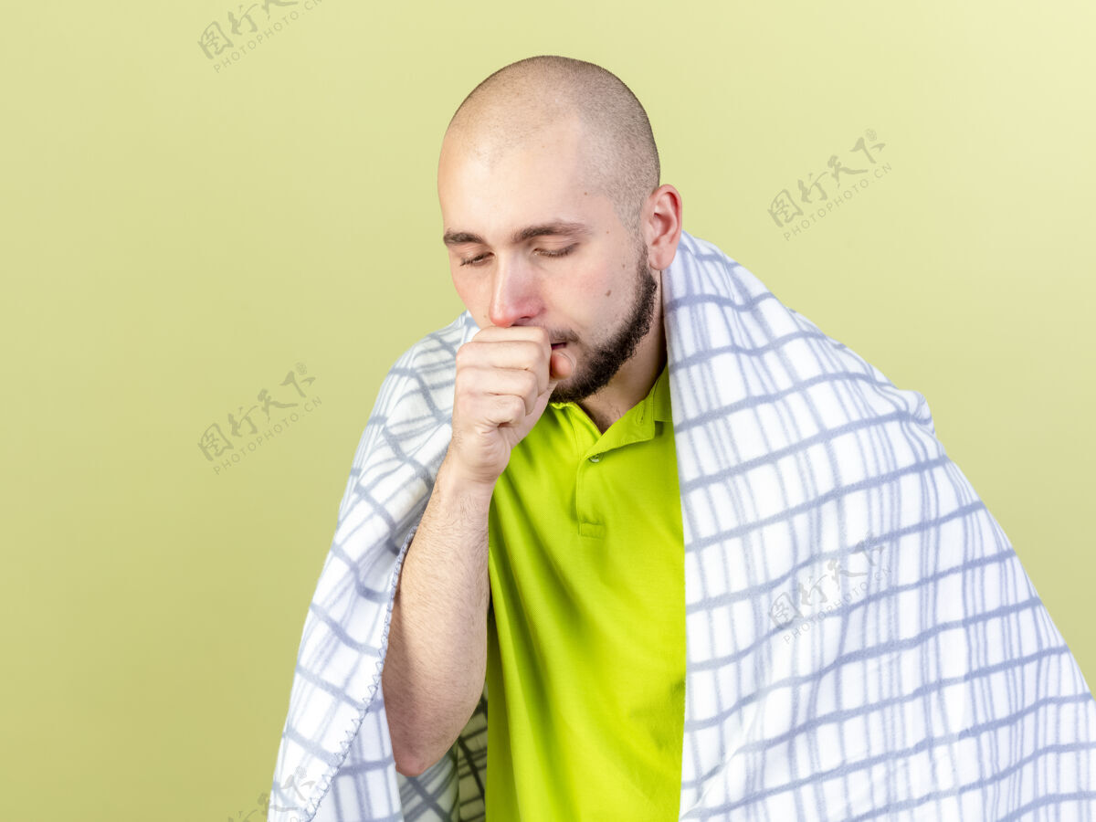 脸苍白的年轻病人裹着格子布咳嗽隔离在橄榄绿的墙上人市民人