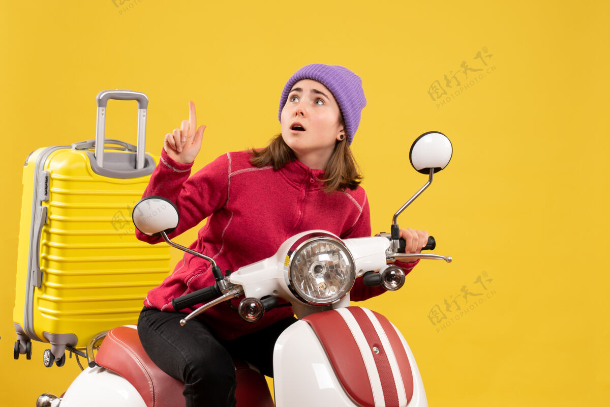 轻便摩托车前视图骑着轻便摩托车的年轻女孩抬头看前面欢乐成人