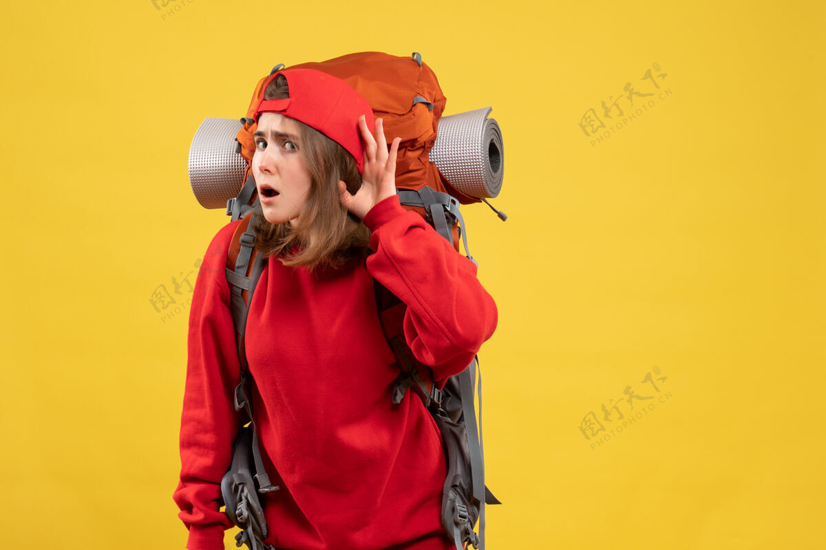 手持正面图年轻女旅客背着背包在听什么正面背包表情