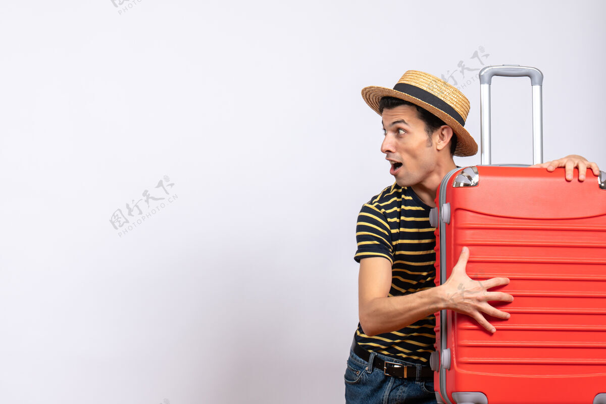 稻草正面图：一个戴草帽拿着手提箱的年轻人人男人风景