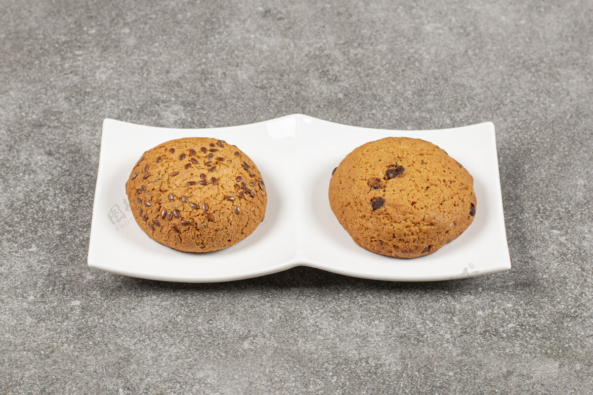 自制两个自制的新鲜饼干放在白色盘子里收藏饼干食品