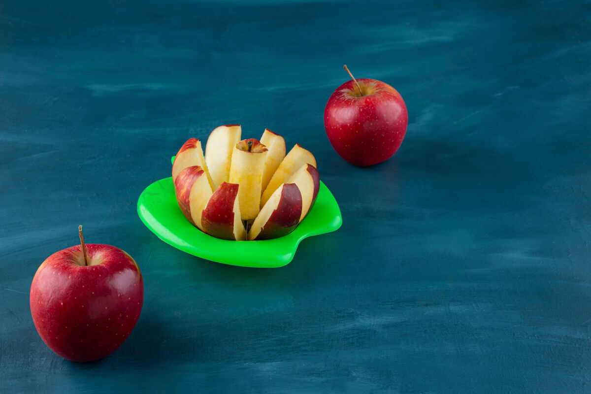美味新鲜切成片的红苹果放在蓝色的表面上多汁的红色健康