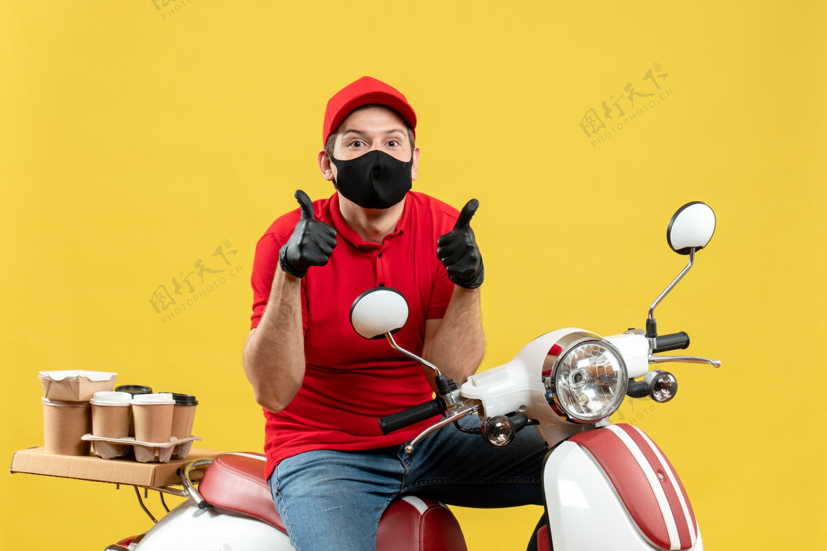 红色俯视图：快递员身穿红色上衣 戴着帽子 戴着手套 戴着医用面罩 坐在滑板车上 做着“ok”的手势 感觉很惊讶摩托车手套好