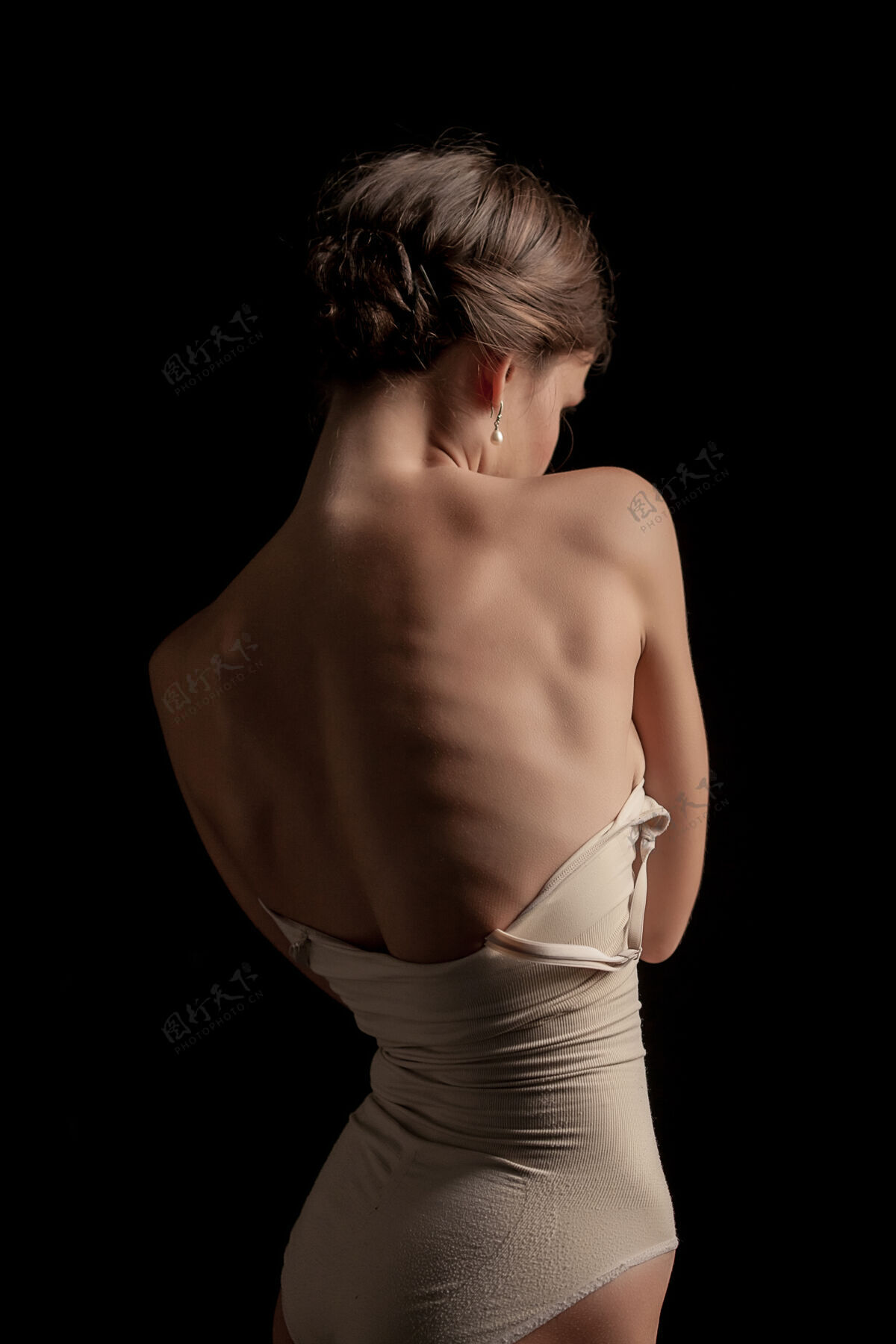肩膀一个美丽的女人 在黑暗的背景上的后视图身体皮肤水疗