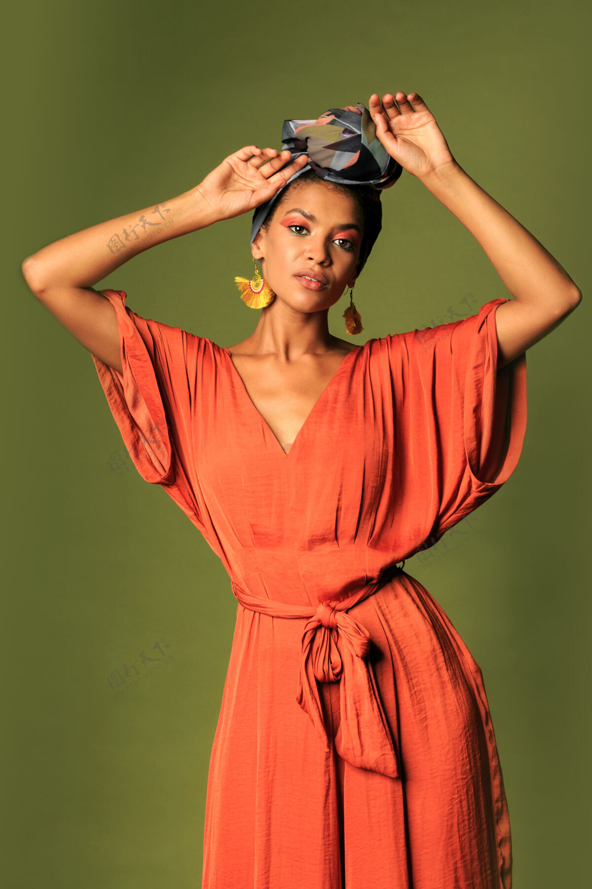 人年轻的女人穿着橙色的裙子 戴着头巾和民族首饰模特头配饰