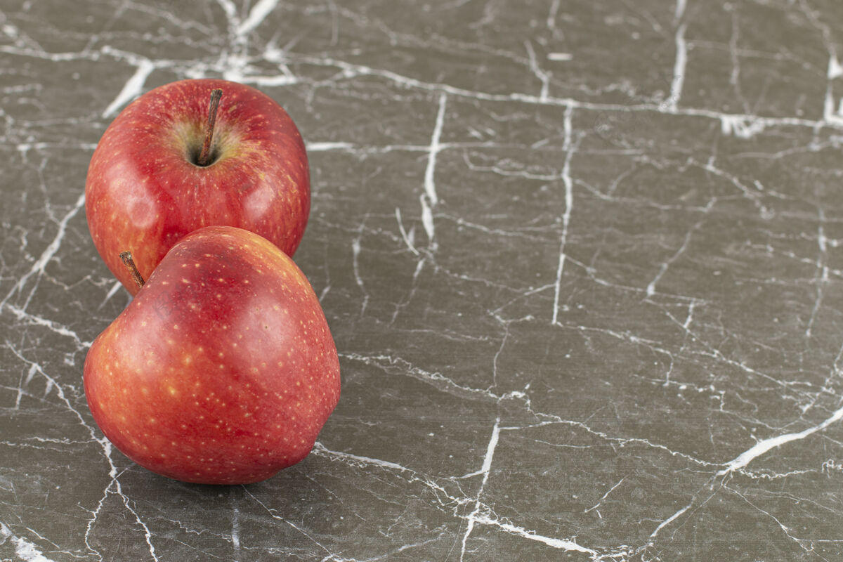 健康灰石上两个新鲜苹果的特写照片多汁光明美味