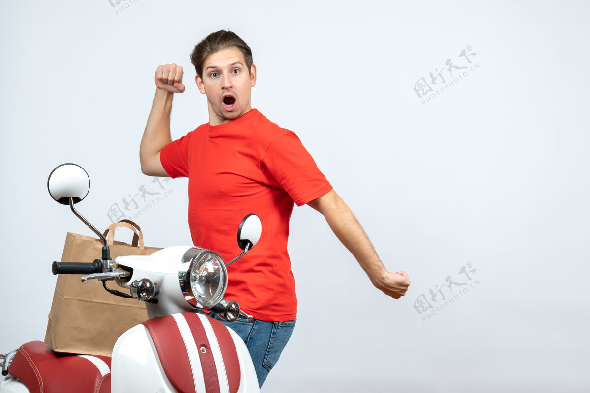 人前视图滑稽疯狂的情感送货员穿着红色制服站在白色背景的滑板车附近成人背景健身