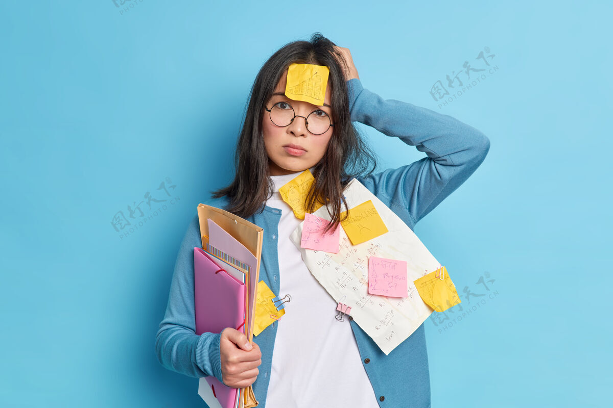 专业失望健忘的年轻女子厌倦了填鸭式的考试 手放在头上 看起来压力很大办公室疲劳专注