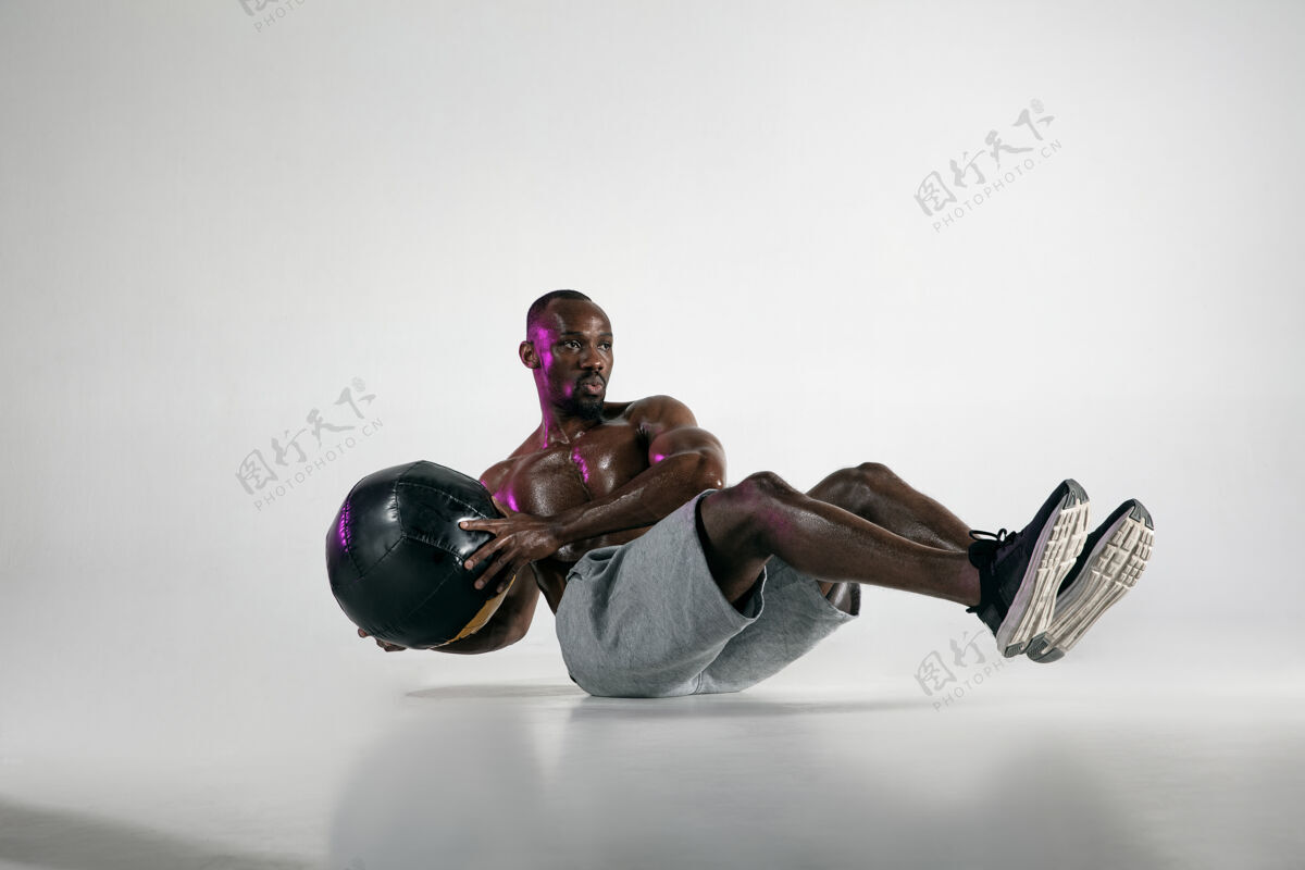 人准备最好的年轻的非洲裔美国人在灰色背景下的健美训练肌肉发达的单一男模在运动服与球概念的运动 健美 健康的生活方式健美运动举重
