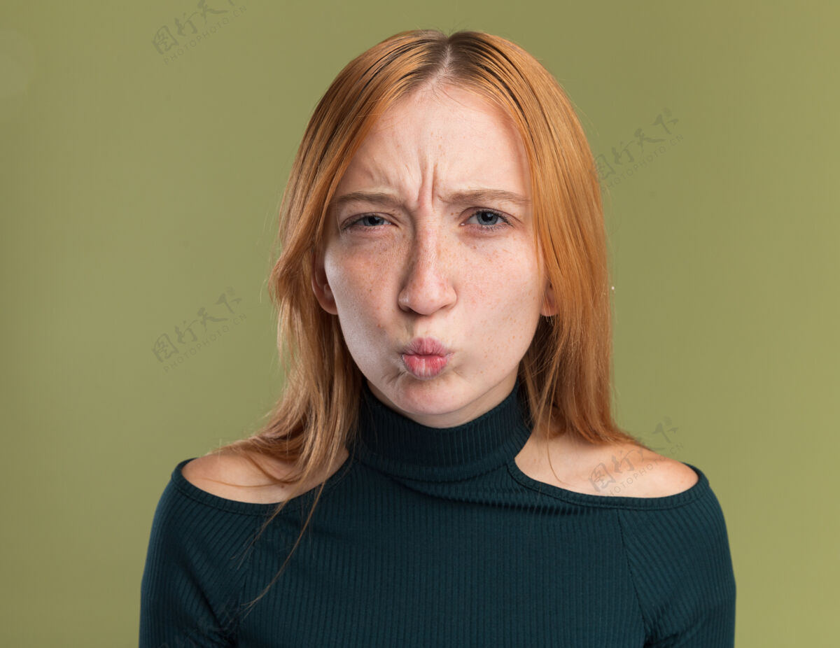 相机一个长着雀斑的年轻红发姜黄色女孩看着橄榄绿的相机雀斑红头发绿色