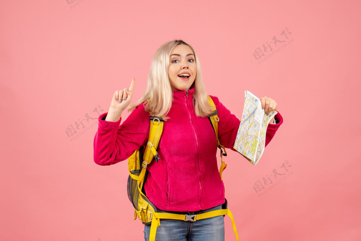 头发正面视图快乐的旅行妇女与黄色背包举行地图指向天花板背包持有肖像