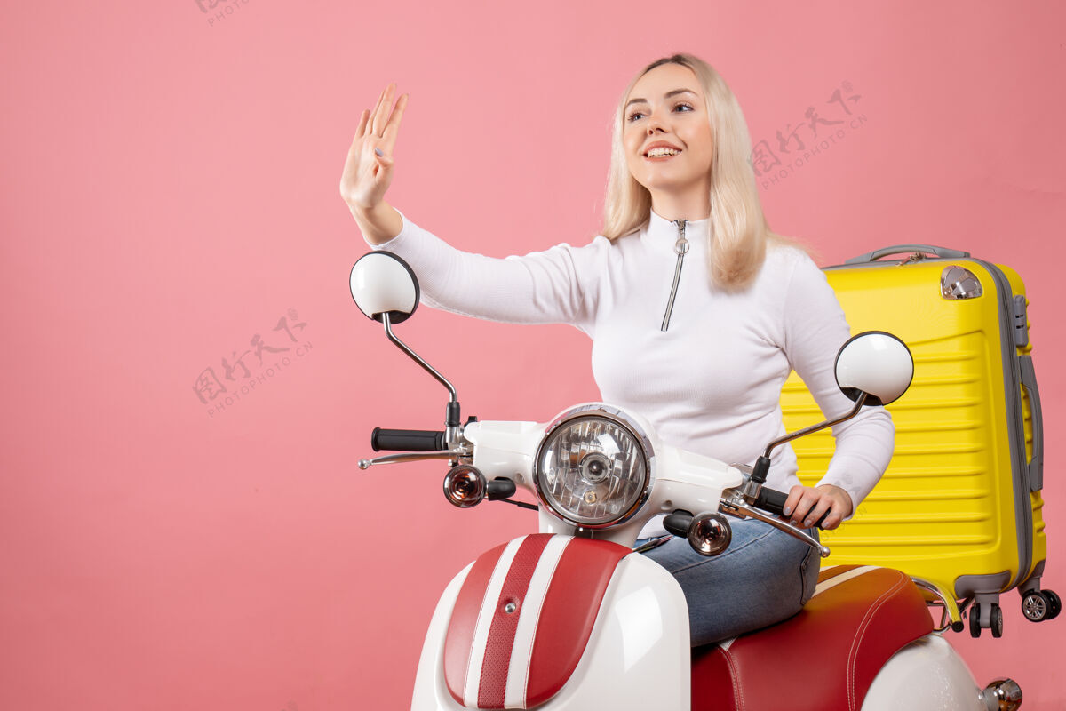 身体前视图：骑着轻便摩托车的快乐小姐示意停车标志人坐着轻便摩托车