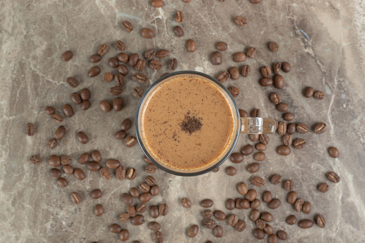 热的一杯热咖啡和咖啡豆放在大理石表面营养美味一餐