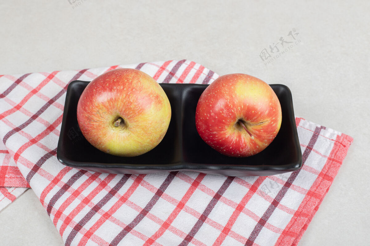 熟的用桌布把整个红苹果放在黑盘子里新鲜水果生的