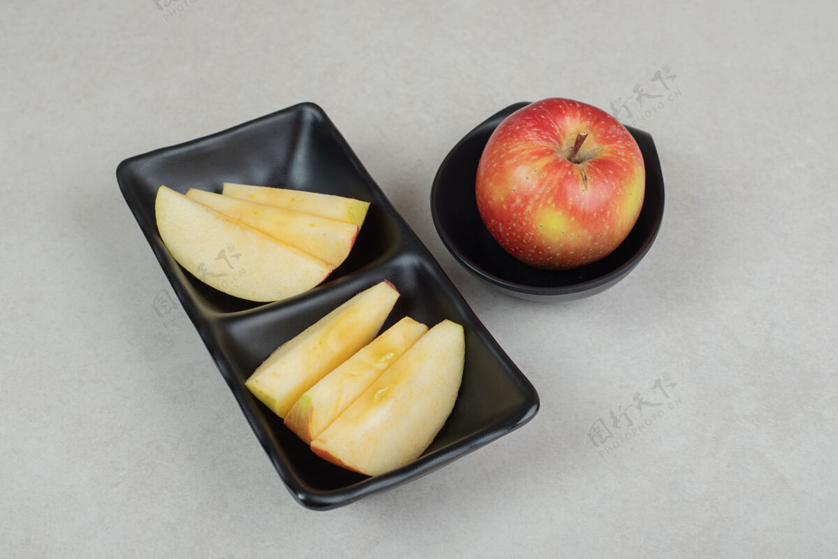 切片把一整片红苹果放在黑盘子里营养可口水果