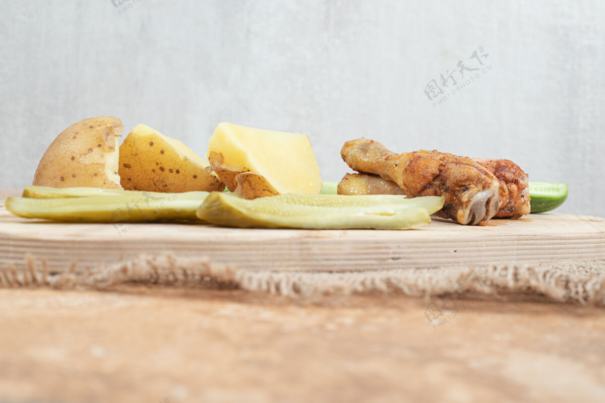 黄瓜木板上有各种蔬菜的鸡腿美味营养切片