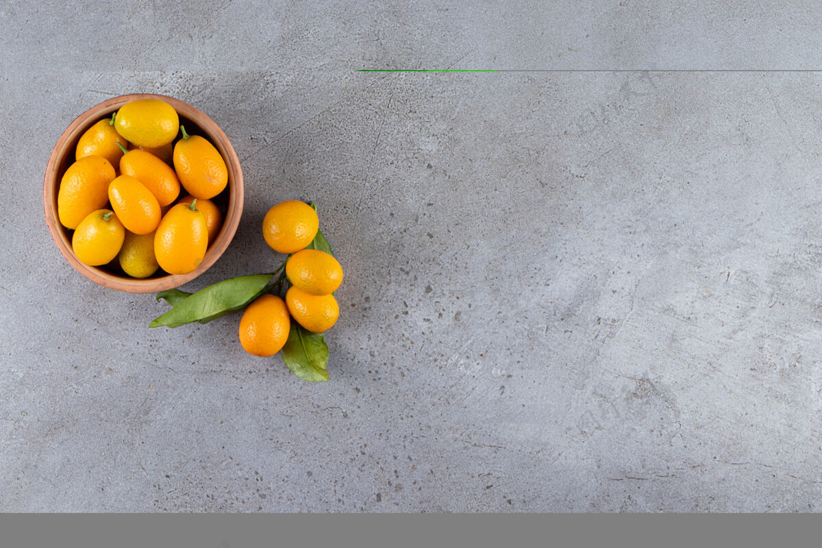 生的新鲜的全柑橘类金橘果实 叶子放在木碗里堆金橘饮食