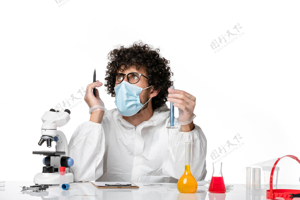 病毒正面图：男医生穿着防护服 戴着口罩 拿着一个装有蓝色溶液的烧瓶 在白色背景上写着大流行性冠状病毒-流行性病毒白色外套大流行