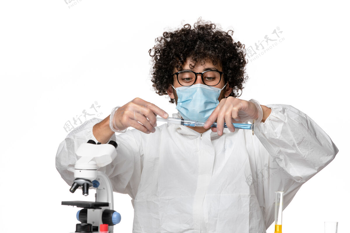 防护正面图：男医生穿着防护服 戴着口罩 在白色背景上注射疫苗-流行性大流行病毒医疗正面医生