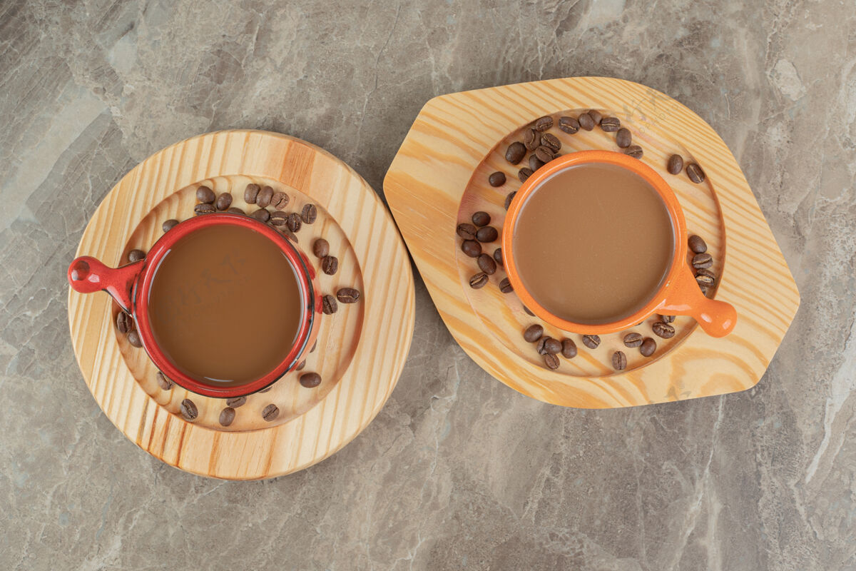 热两杯咖啡和咖啡豆放在木盘上豆烤咖啡